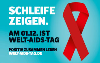 Schleife zeigen. Am 01.12. ist Welt-Aids-Tag.