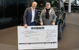 Volker Dönges (l.), der Leiter der Mendener Niederlassung des Autohauses Rosier, übergibt die Spende aus dem Charity-Adventskalender an Peter Müller (r.).